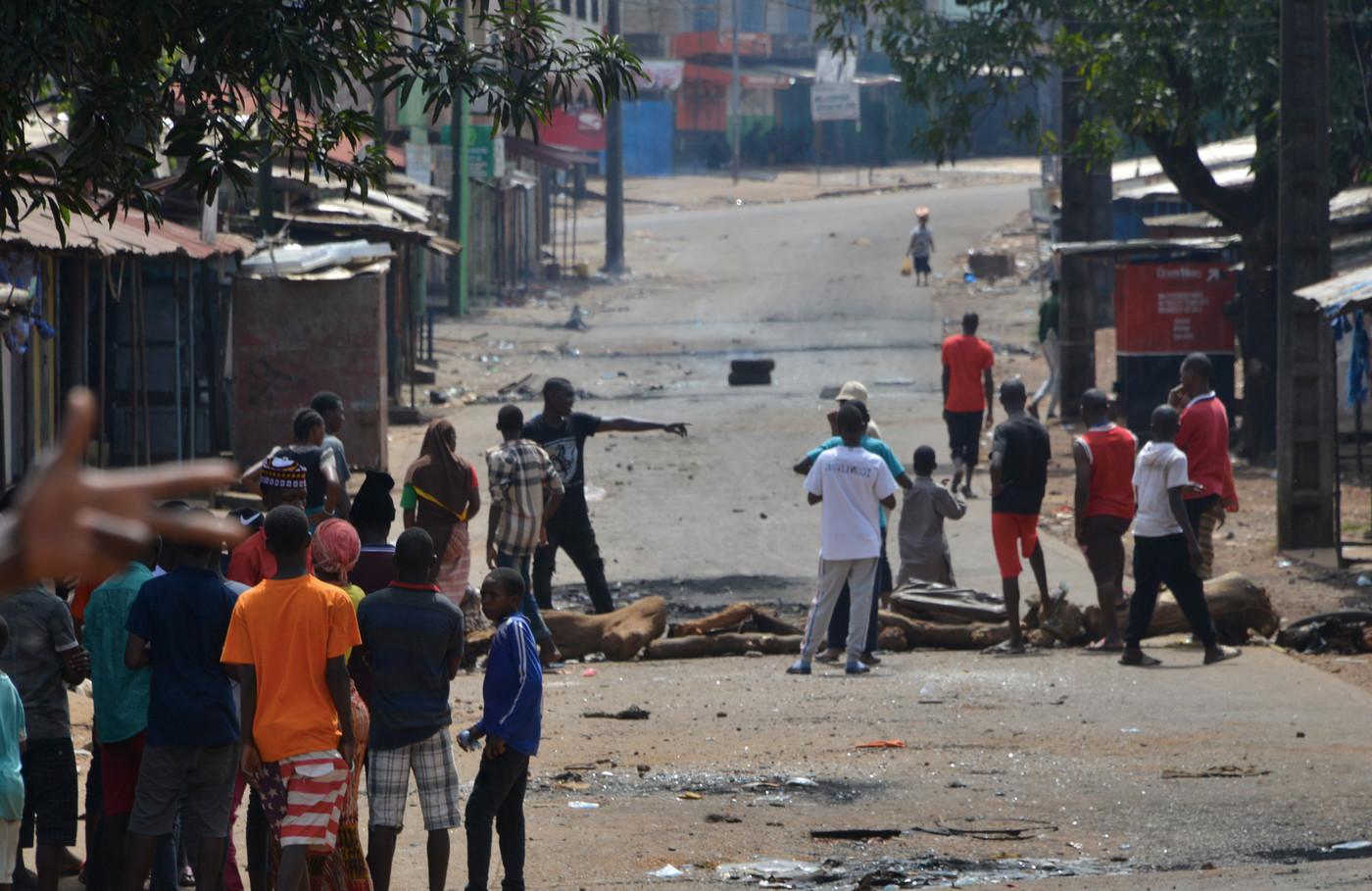 Young people block the road as they protest against a possible third term of President Alpha Conde on October 16, 2019, in Conakry. – A Guinea court on October 16, 2019, suspended the trial of eight opposition leaders accused of organising protests against President Alpha Conde, as fresh rioting broke out in the capital Conakry. The opposition says at least 10 people have died in three days of deadly clashes during opposition protests against Conde&rsquo;s push for constitutional reforms that critics say aim at letting him to run for a third term. (Photo by CELLOU BINANI / AFP)