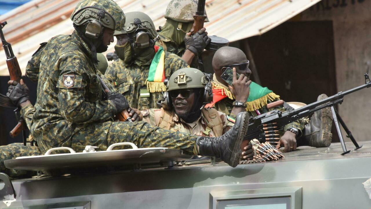 Members of Guinea&rsquo;s armed forces celebrate after the arrest of Guinea&rsquo;s president, Alpha Conde, in a coup d&rsquo;etat in Conakry on September 5, 2021. – Guinean special forces seized power in a coup on September 5, arresting the president and imposing an indefinite curfew in the poor west African country. « We have decided, after having taken the president, to dissolve the constitution, » said a uniformed officer flanked by soldiers toting assault rifles in a video sent to AFP. (Photo by CELLOU BINANI / AFP)