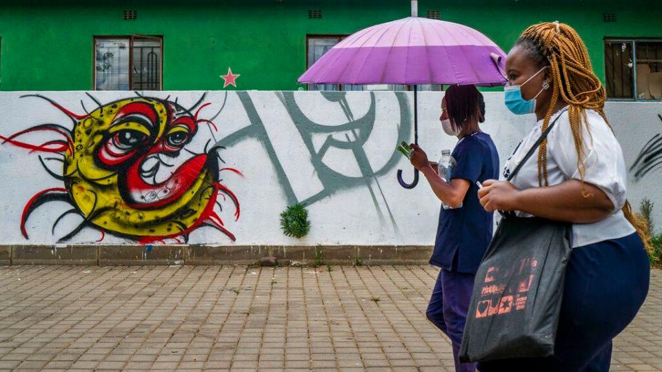 Two women walk past a COVID-19 graffiti in Soweto’s Orlando West township near Johannesburg, South Africa, Thursday Nov. 19, 2020. Africa has surpassed 2 million confirmed coronavirus cases as the continent’s top public health official warns that “we are inevitably edging toward a second wave” of infections. The 54-nation continent of 1.3 billion people is being warned against “prevention fatigue” as countries loosen pandemic restrictions to ease their economies’ suffering and more people travel. (AP Photo/Jerome Delay)