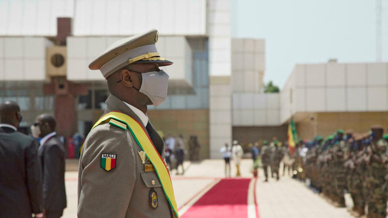New interim Malian President, Colonel Assimi Goita, looks on at members of the Malian Armed Forces after his swearing in ceremony in Bamako on June 7, 2021. (Photo by ANNIE RISEMBERG / AFP)