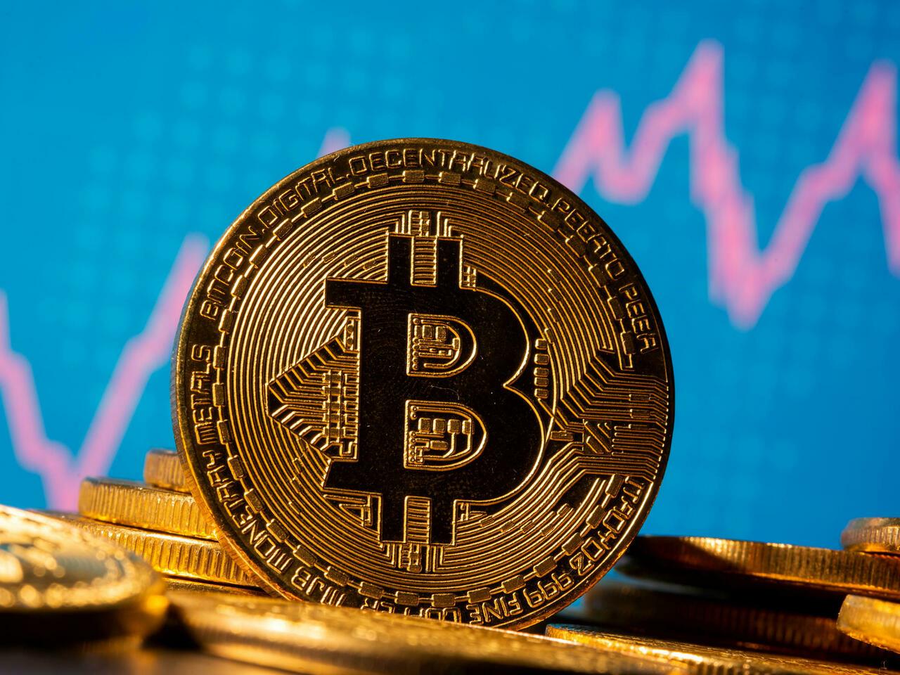 FILE PHOTO: A representation of virtual currency Bitcoin is seen in front of a stock graph in this illustration taken November 19, 2020. REUTERS/Dado Ruvic/Illustration/File Photo