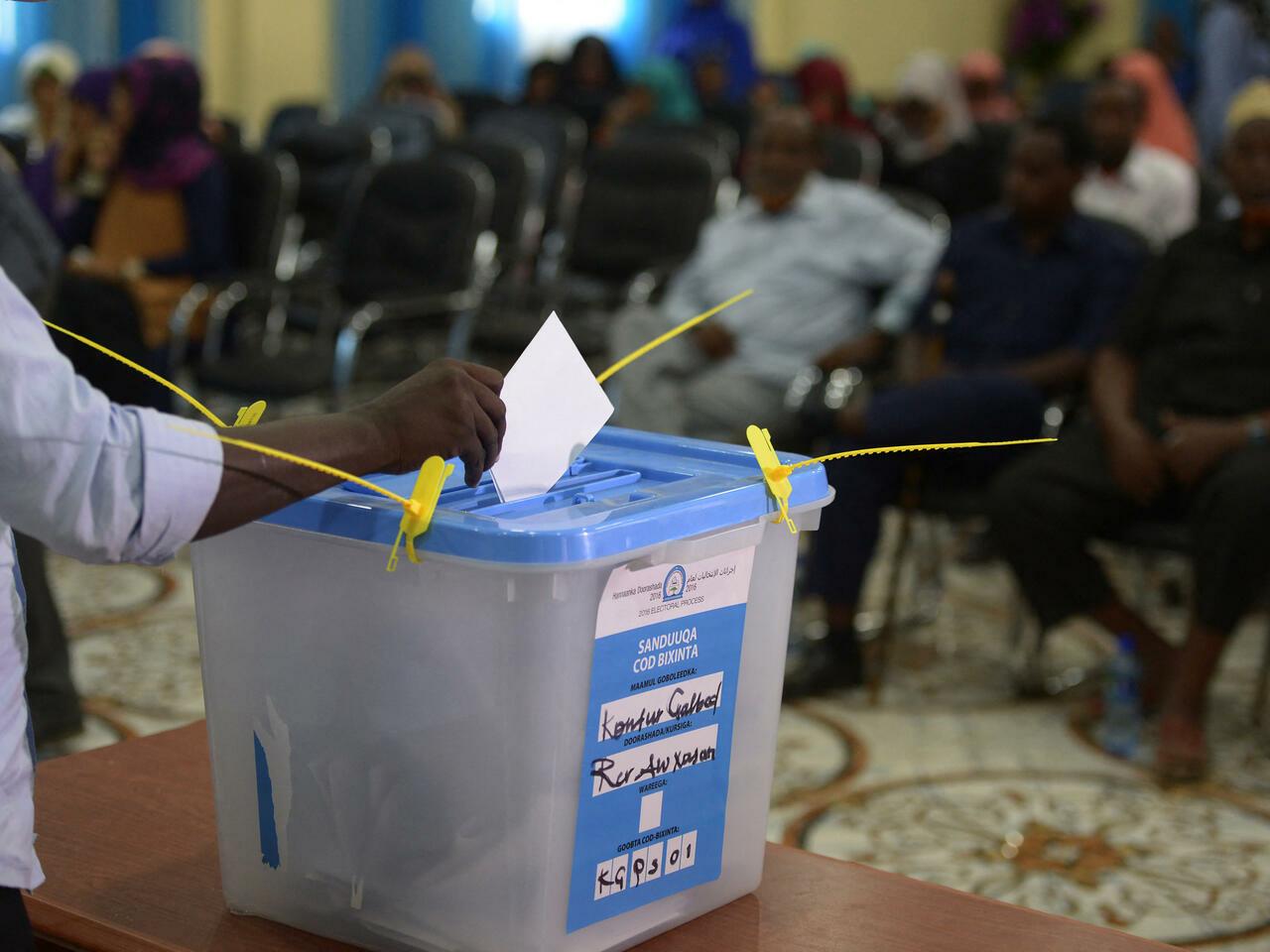 (FILES) In this file photo taken on November 16, 2016 A person casts her ballot at a polling station in Baidoa. – Somalia will hold presidential elections on May 15, 2022 state TV announced on May 5, 2022, broadcasting a statement by a committee preparing for the vote which has been delayed by over a year. (Photo by SIMON MAINA / AFP)