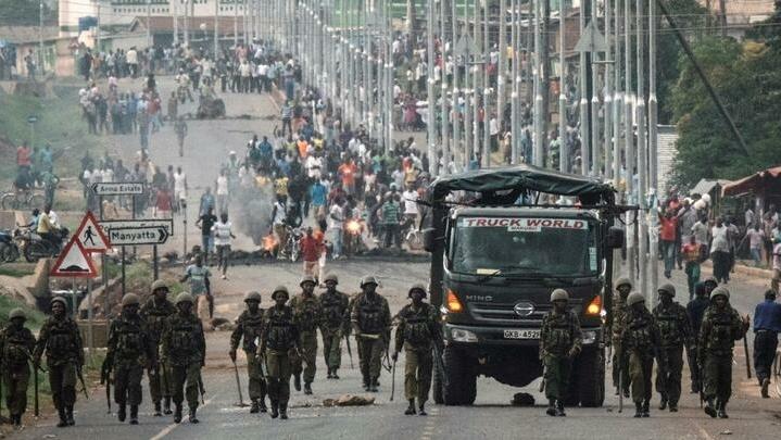 Police officers patrol the road barricaded by National Super Alliance (NASA) supporters during a protest against Kenya’s second poll in Kisumu, on October 27, 2017. Kenya’s election chief said on October 27 plans to restage a presidential vote on October 28 in areas hit by polling-day protests would be postponed « to a further date » because of fresh violence. / AFP PHOTO / YASUYOSHI CHIBA