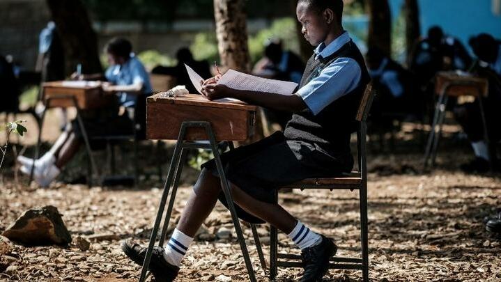 Students of St Dominic Bukna Secondary school take their English test outside due to their overcrowded class room in Kisumu, Kenya, on May 31, 2018. (Photo by Yasuyoshi CHIBA / AFP)