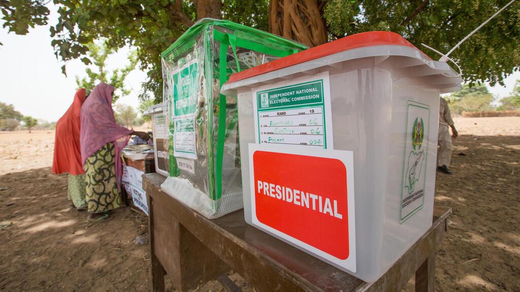 Voters prepare to cast theor ballots at a polling station set up under a tree on the outskirt of Kano during the presidential elections on March 28, 2015. Voting began in Nigeria’s general election but delays were reported countrywide because of technical problems in accrediting electors. There was a mixed picture across the country, with people at some polling units reporting no problems in casting their ballot from 1230 GMT but others still waiting for their identities to be checked. AFP PHOTO/TOM SAATER