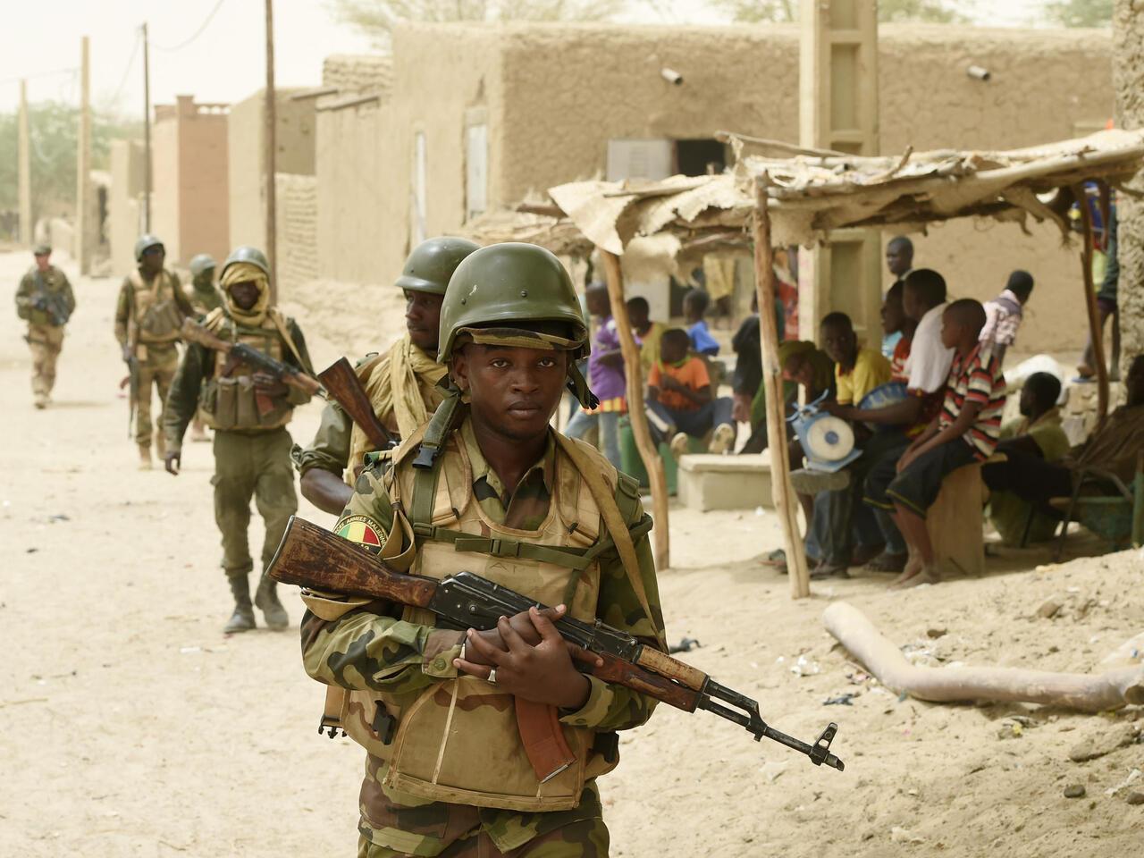 Malian army soldiers patrol after arresting two suspected looters in the village of Bintagoungou on June 4, 2015, near Goundam 80 km east of Timbuktu, central Mali during a joint operation « La Madine 3 » with French soldiers of the 93 th Regiment d’Artillerie de Montagne (based in Vars, southeastern France) of Operation Barkhane, an anti-terrorist operation in the Sahel. AFP PHOTO / PHILIPPE DESMAZES